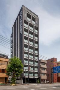 广岛HOTEL SUITE HIROSHIMA HAKUSHIMA的一座高大的建筑,旁边有一个标志