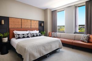 约克Malmaison York的一间卧室配有一张床、一张沙发和窗户。