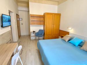 佩鲁贾西尼亚住宅公寓式酒店的一间卧室配有蓝色的床和一张桌子及椅子