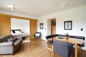 蒂罗尔-泽费尔德Hotel Berghof的客厅配有沙发和1张床