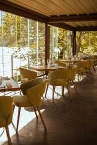 冈多菲堡库拉湖酒店的用餐室设有桌椅和窗户。