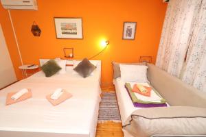 科尔丘拉Guest House Jungher的橙色墙壁客房中的两张单人床