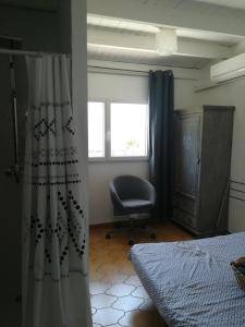 土伦Cath's place的卧室配有床、椅子和窗户。