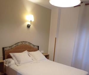 坎加斯-德奥尼斯托雷翁旅馆的卧室配有白色床,墙上有灯