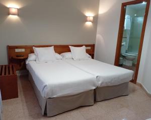 坎加斯-德奥尼斯托雷翁旅馆的一间带大床的卧室和一间浴室