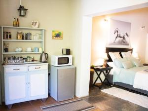 KaapsehoopPanda's Guest Cottages的一间卧室配有一张床和一台微波炉