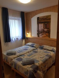 费拉迪普利米罗Casa Alice 5.5的一间卧室设有两张床和大镜子