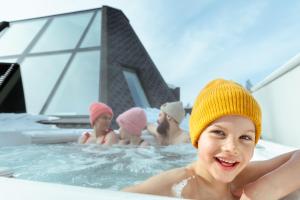 罗瓦涅米Glass Resort的戴帽子的妇女在热水浴池中