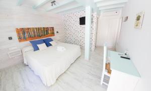 塔里法拉托雷酒店的卧室配有白色的床和蓝色枕头