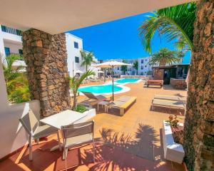 卡门港大西洋俱乐部酒店的一个带椅子的庭院和一个棕榈树游泳池