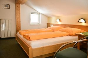 施勒肯Haus Alpenblick的一间卧室配有一张带橙色床单的大床