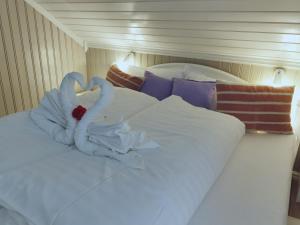 拉姆贝格BanPim Beachside Lofoten的床上用毛巾制成的两天鹅