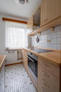 比苏梅尔代肖森Ferienwohnung von Postel的厨房配有木制橱柜、水槽和窗户。
