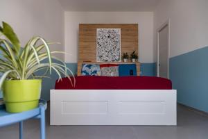 利多康奇耶Casa di Marco Lungomare Jonio的卧室配有一张带红色毯子的白色床