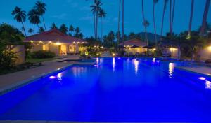 利巴诺伊暹罗原住精品度假酒店的夜间度假村内带蓝色灯光的游泳池