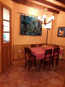 隆达Viviendas Turísticas Los Arrayanes的用餐室配有粉红色的桌子和椅子