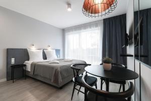 斯维诺乌伊希切ApartPark Baltic Home的一间卧室配有一张床和一张桌子及椅子