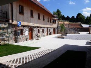 Stari Trg pri LožuYouth Hostel Arsviva的一座石头建筑,前面设有停车场