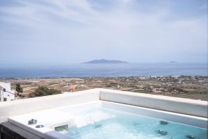 Éxo GoniáDeep Earth Villas的阳台的热水浴池,背景为大海