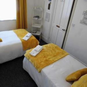 霍尔斯沃西Kings Arms Hotel的酒店客房,配有两张带毛巾的床