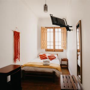阿雷基帕Maison verte - Guest House的卧室配有一张床铺,墙上配有电视