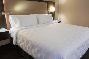 温哥华温哥华市中心假日套房酒店的一张大白色的床,位于酒店客房内