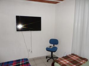 尤西德福拉Hospedagem Progresso的一间房间,墙上有椅子和电视