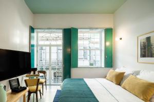 阿马兰特Covelo - The Original Rooms and Suites的配有一张床、一张桌子和一张桌子的酒店客房