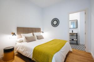 塞维利亚Magno Apartments Alameda 1851 - Shared jacuzzi的白色卧室配有一张带黄色毯子的大床