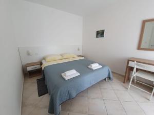 塞尔瑟Apartmani Plaža的一间卧室配有一张床,上面有两条毛巾