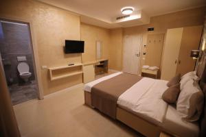 北马马亚-讷沃达里Hotel Grand Dedal的一间卧室配有一张床,浴室设有卫生间