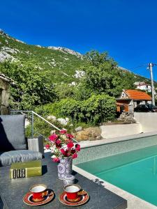 加塔Maison Laurel - Exquisitely Renovated Centuries Old Stone Estate With Private Pool, Near Split and Omiš的一张桌子,上面有两杯,花瓶