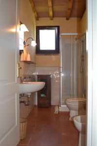 格罗塞托港Agriturismo Beveraggio Appartamenti的一间带两个盥洗盆、淋浴和卫生间的浴室