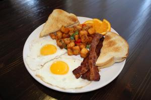 皮奥里亚大草原城皮奥里亚假日套房酒店的包括鸡蛋培根和烤面包的早餐食品