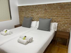 萨里亚Oktheway Pedro Saco Street的一间卧室设有两张床和砖墙