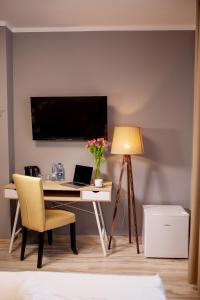 格丁尼亚Kamienica Morska Gdynia的客房配有带笔记本电脑和台灯的书桌。