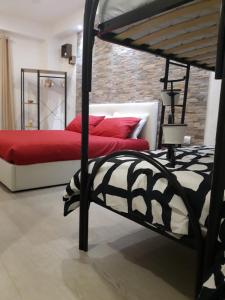 玛格丽塔萨沃亚Maison Marguerite的一间卧室配有两张带红色枕头的床