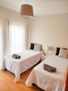 奥良Apartamento Marina Olhão的一间卧室配有两张带毛巾的床