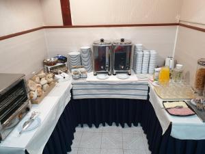阿威罗Hotel Palmeira的一间房间,桌子上摆放着食物和饮料
