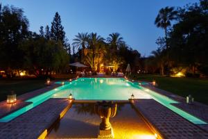 马拉喀什达艾尼文花园酒店&鸟类动物园 的夜间游泳池,灯光照亮