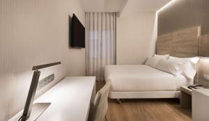 马德里NH马德里贝里酒店的小酒店客房配有一张床和一张书桌