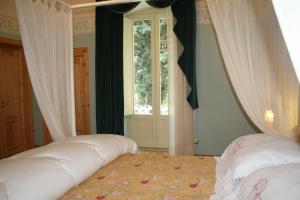 卡萨诺德莱穆尔杰Casarosa B&B de Charme的一间卧室配有带窗帘的床和窗户