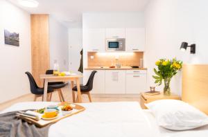 斯祖贝莱克Apartmán Vila Zuberec的一间带一张床的房间和一间带桌子的厨房