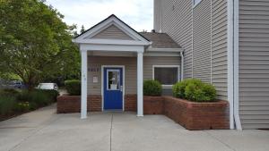 诺克斯维尔InTown Suites Extended Stay Knoxville TN的一座带蓝色门和砖墙的房子