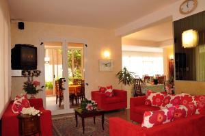 里乔内Hotel Rita的客厅配有红色沙发和电视