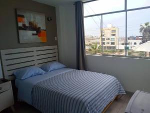 万查科Hospedaje Nuna - Playa Huanchaco的一间卧室设有一张床和一个大窗户