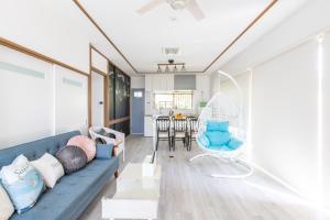 白滨West Coast Villa Shirahama的客厅配有蓝色的沙发和椅子