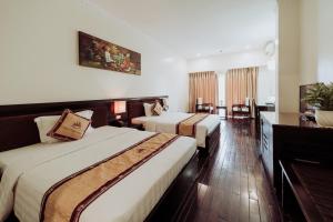 Thái BìnhWhite Palace Thai Binh Hotel的酒店客房设有两张床和电视。
