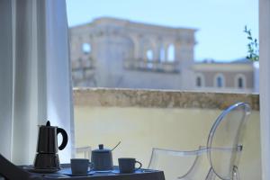莱切Luxury House Lecce -Le mie 3 Suites-的一张桌子,上面有杯子,享有建筑的景色