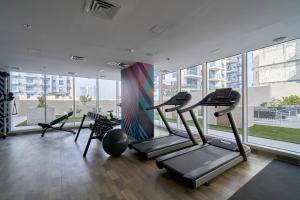 迪拜Stella Stays Fabulous Studio Dubai JVC Large Terrace的带有氧器材的健身房,位于带窗户的大楼内